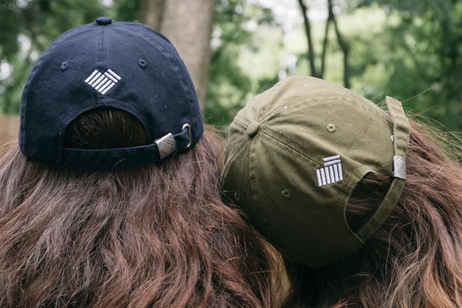 Green and navy hat with white logo embroidery on back