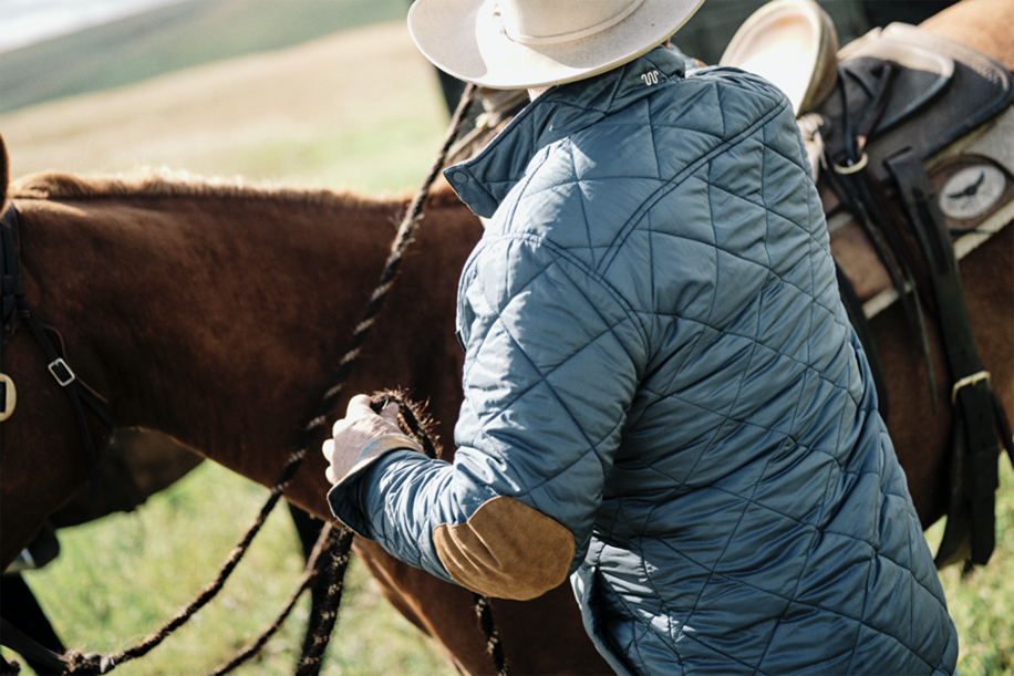 Man next to horse in King Ranch Jacket